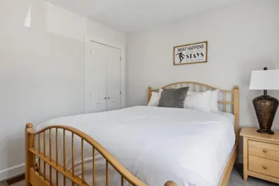 a bedroom with a bed and a night stand with a lamp at Townhouse with Hot Tub near Blue Mountain Village - 162 Vacation Inn in Collingwood