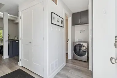 a white hallway with a washing machine in a room at Townhouse with Hot Tub near Blue Mountain Village - 162 Vacation Inn in Collingwood