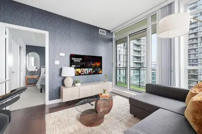 a living room with a couch and a tv at Stylish Downtown - Condo Sleeps 8 - YYZ Airport in Mississauga