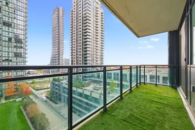 a balcony with a view of a tall building at Stylish Downtown - Condo Sleeps 8 - YYZ Airport in Mississauga