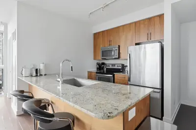 a kitchen with a sink and a refrigerator at Stylish Downtown - Condo Sleeps 8 - YYZ Airport in Mississauga