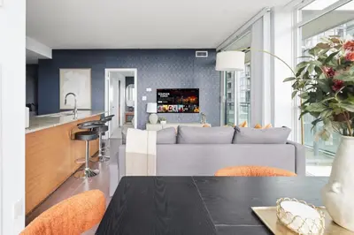 a kitchen and living room with a couch and a table at Stylish Downtown - Condo Sleeps 8 - YYZ Airport in Mississauga