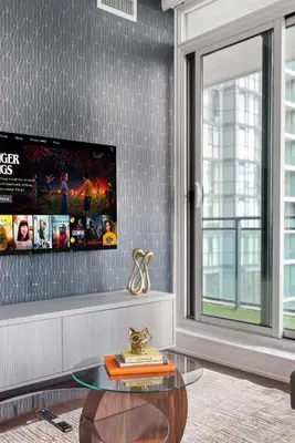 a living room with a glass table and a tv at Stylish Downtown - Condo Sleeps 8 - YYZ Airport in Mississauga