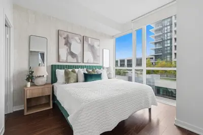 a bedroom with a large bed and large windows at Sleek Sq 1 Downtown Condo - 4 beds - Parking in Mississauga