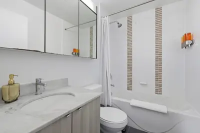 a bathroom with a sink and a toilet and a mirror at Sleek Sq 1 Downtown Condo - 4 beds - Parking in Mississauga