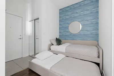 two beds in a room with a painting on the wall at Sleek Sq 1 Downtown Condo - 4 beds - Parking in Mississauga