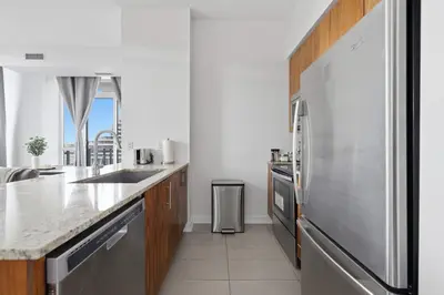 a kitchen with a stainless steel refrigerator and a sink at Sleek Sq 1 Downtown Condo - 4 beds - Parking in Mississauga