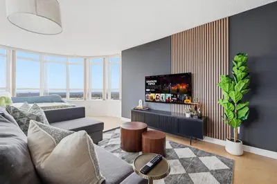 a living room with a couch and a tv at Stylish 2br High-Rise - Sleeps 7 - YYZ in Mississauga