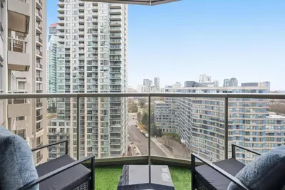 a balcony with chairs and a view of a city at Stylish 2br High-Rise - Sleeps 7 - YYZ in Mississauga