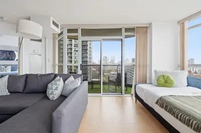 a living room with a couch and a large window at Stylish 2br High-Rise - Sleeps 7 - YYZ in Mississauga