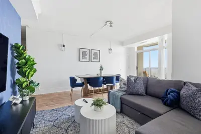 a living room with a couch and a table at Stylish 3br Condo - Parking - 65 TV in Mississauga