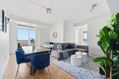 a living room with a couch and a table at Stylish 3br Condo - Parking - 65 TV in Mississauga
