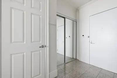 an empty hallway with a door and a mirror at Stylish 3br Condo - Parking - 65 TV in Mississauga