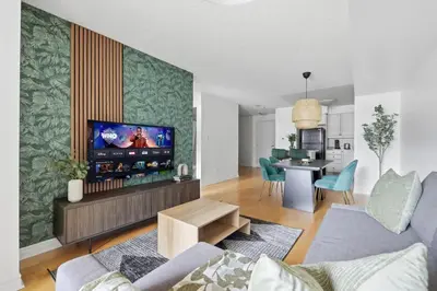 a living room with a couch and a tv in it at Tropical Designer King Suite - Sleeps 5 - Parking in Mississauga