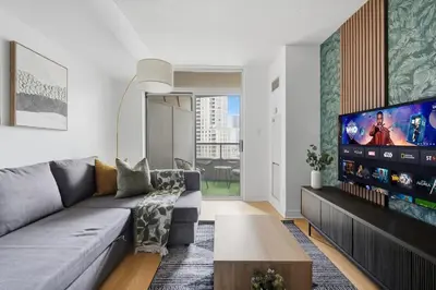 a living room with a couch and a flat screen tv at Tropical Designer King Suite - Sleeps 5 - Parking in Mississauga