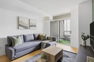 a living room with a blue couch and a table at Tropical Designer King Suite - Sleeps 5 - Parking in Mississauga