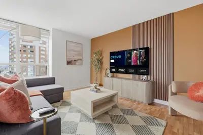 a living room with a couch and a tv at Elegant 2BR Sky Condo for 9 - Terrace - Lake Views in Mississauga