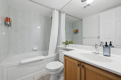 a white bathroom with a toilet and a sink at Elegant 2BR Sky Condo for 9 - Terrace - Lake Views in Mississauga