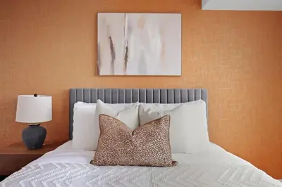 a bedroom with a bed with white sheets and pillows at Elegant 2BR Sky Condo for 9 - Terrace - Lake Views in Mississauga