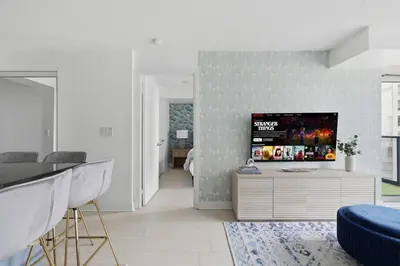 a living room with a flat screen tv on a wall at Designer 2BR - King Suite - Rare 2 Parking - YYZ in Mississauga
