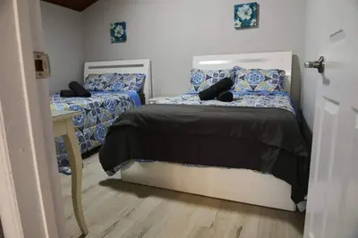 a bedroom with two beds with blue and white sheets at Modern 4BR Lake Escape with Patio & BBQ Area in Kawartha Lakes