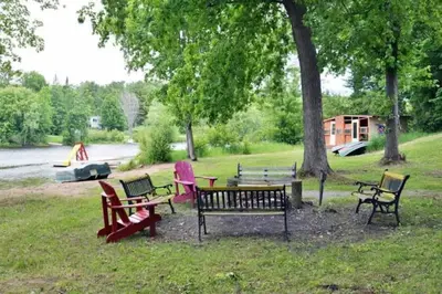 a group of park benches sitting in the grass at Modern 4BR Lake Escape with Patio & BBQ Area in Kawartha Lakes
