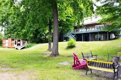 a park with two benches in front of a building at Modern 4BR Lake Escape with Patio & BBQ Area in Kawartha Lakes