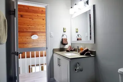 a bathroom with a sink and a mirror at Modern 4BR Lake Escape with Patio & BBQ Area in Kawartha Lakes