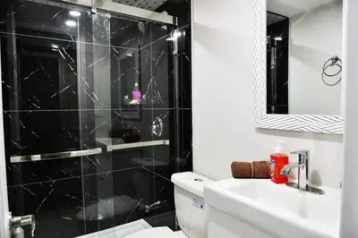 a bathroom with a shower and a toilet and a sink at Modern 4BR Lake Escape with Patio & BBQ Area in Kawartha Lakes