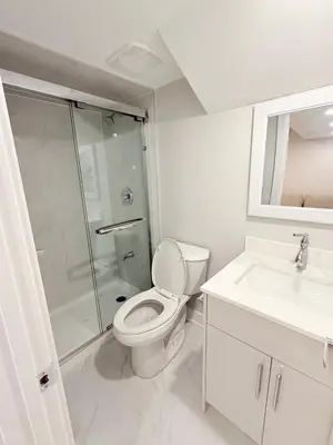 a bathroom with a toilet and a shower and a sink at Studio Basement Suite with Sofa Bed and kitchen, Entrance from Garage -Sleeps 2 in Milton