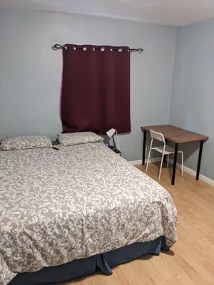 a bedroom with a bed and a desk and a table at Private Room In Hamilton 2 in Hamilton
