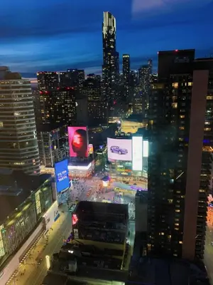a view of a city at night with billboards at The Vicky - Centre of Attention - Location Design in Toronto
