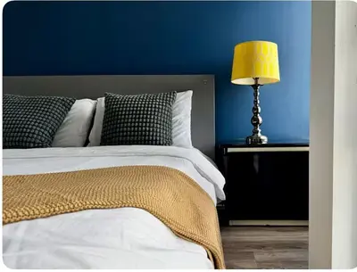 a blue bedroom with a bed with a yellow lamp at The Vicky - Centre of Attention - Location Design in Toronto