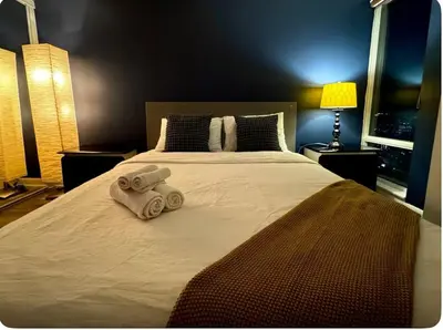 a bedroom with a large bed with two towels on it at The Vicky - Centre of Attention - Location Design in Toronto