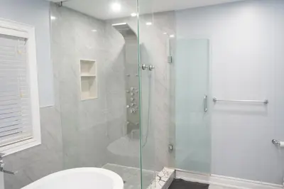 a bathroom with a glass shower with a toilet at Luxury 5BR Home with Spa Bath in Burlington