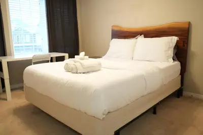 a bedroom with a large bed with white sheets at Luxury 5BR Home with Spa Bath in Burlington