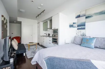 a bedroom with a large bed and a kitchen at Lake view Studio Condo High Floor Downtown Toronto in Toronto