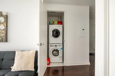a laundry room with a washer and dryer in it at Lake view Studio Condo High Floor Downtown Toronto in Toronto
