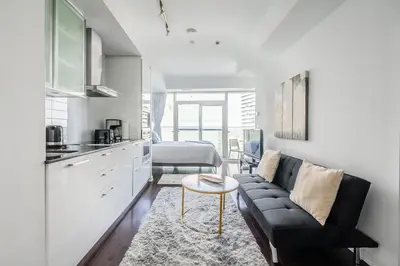 a living room with a couch and a kitchen at Lake view Studio Condo High Floor Downtown Toronto in Toronto
