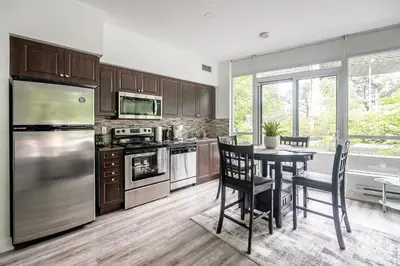 a kitchen with stainless steel appliances and a table with chairs at Private Entrance 2 Bedroom Condo Downtown Toronto in Toronto