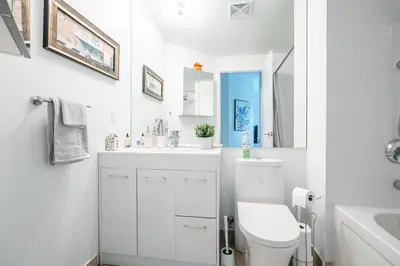 a white bathroom with a toilet and a sink at Private Entrance 2 Bedroom Condo Downtown Toronto in Toronto