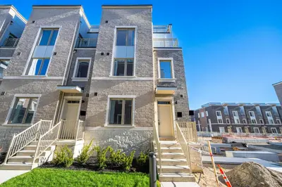 an apartment building with stairs in front of it at Centrally Located 3-Bedroom Townhouse in Vaughan in Vaughan