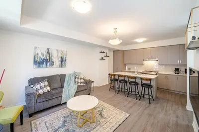 a living room and kitchen with a couch and a table at Centrally Located 3-Bedroom Townhouse in Vaughan in Vaughan