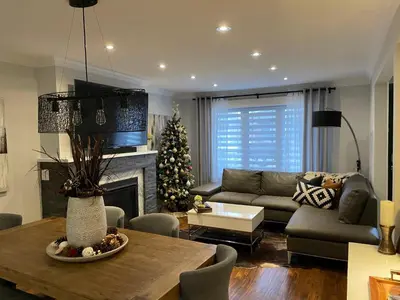 a living room with a couch and a christmas tree at Beautiful Home with Hot tub by YYZ, 20min to CN Tower in Toronto