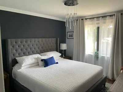 a bedroom with a large bed with a blue pillow on it at Beautiful Home with Hot tub by YYZ, 20min to CN Tower in Toronto