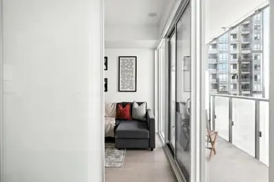 a living room with a couch and a large window at Chic Downtown Retreat with Private Patio in Toronto