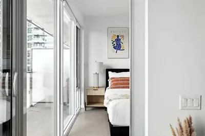 a bedroom with a bed and a large mirror at Chic Downtown Retreat with Private Patio in Toronto