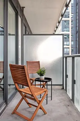 a chair and a table on a balcony at Chic Downtown Retreat with Private Patio in Toronto