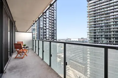 a balcony with a chair and a view of a city at Chic Downtown Retreat with Private Patio in Toronto