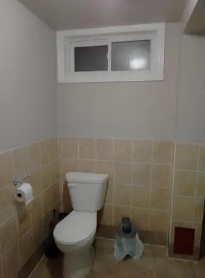 a bathroom with a toilet and a window at Central Location New Year Stay- Free Parking & Fast Wifi in Kitchener
